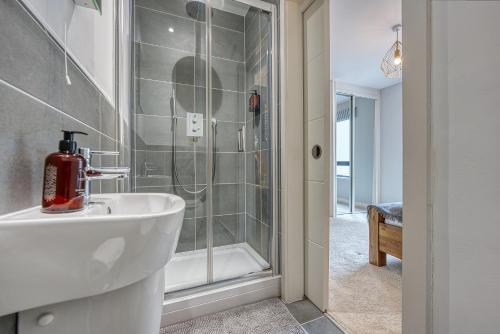 a bathroom with a shower and a white sink at Stunning 2-Bed City Apt - Stylish, Modern, Prime Location! Sleeps 6, Southampton Ocean Village - By Blue Puffin Stays in Southampton