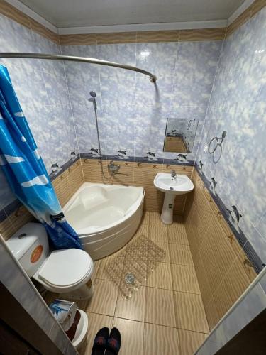 a bathroom with a toilet and a tub and a sink at Art House Boutique Hotel in Khiva