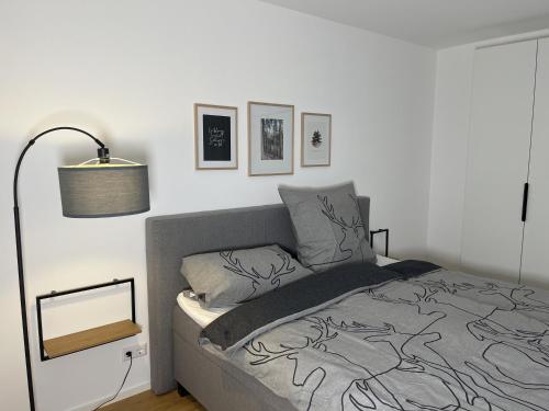 a bedroom with a bed and a lamp and pictures on the wall at Coucou - Nest im Schwarzwald in Gengenbach