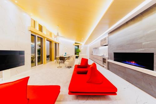 Hakuba Amber Resort by Jade Group في هاكوبا: غرفة معيشة بأثاث احمر وموقد