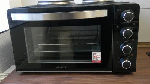 a black microwave oven sitting on top of a table at Unseburger Brauhaus GmbH Ferienwohnung 2 in Unseburg