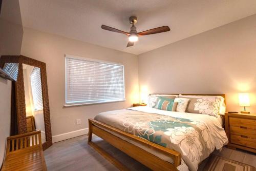 um quarto com uma cama e uma ventoinha de tecto em NEW! Chic & Cozy Lantana near the Beach & Flagler em New Smyrna Beach