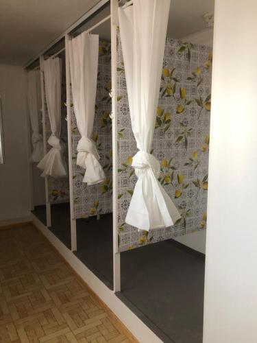 una fila de cortinas blancas en una habitación en Urban rest zone and coworking, en Arrecife