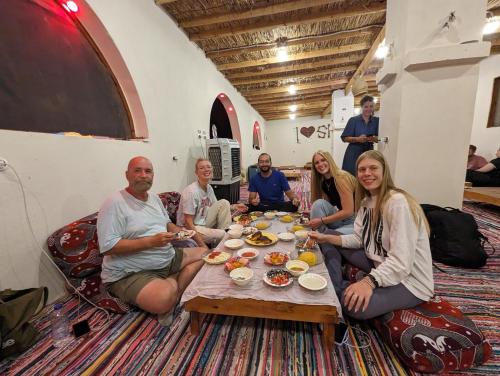 a group of people sitting around a table eating at Cafour House Siwa - Hot Spring in Siwa