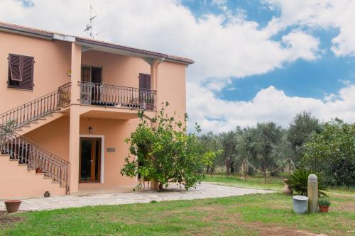 ein Haus mit einem Balkon und einem Hof in der Unterkunft Villa Orta - Agriturismo con cucina Vegan, Plant-based Farmhouse in Riotorto