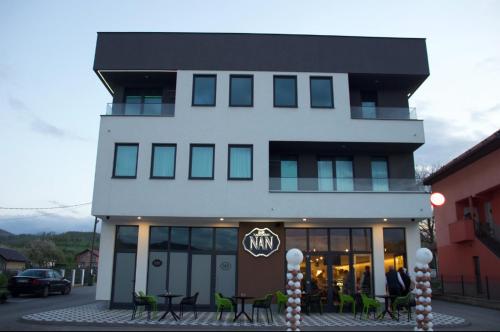 a building with tables and chairs in front of it at Apartmani NAN in Visoko
