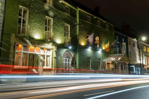 a city street at night with buildings and lights at Club House Hotel Kilkenny in Kilkenny