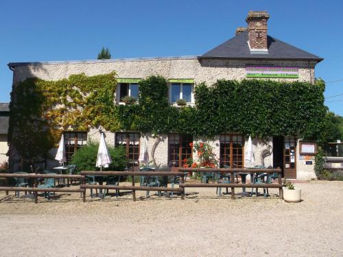 a building with benches in front of it at Logis Hôtel Restaurant Auberge Saint Martin in Surville
