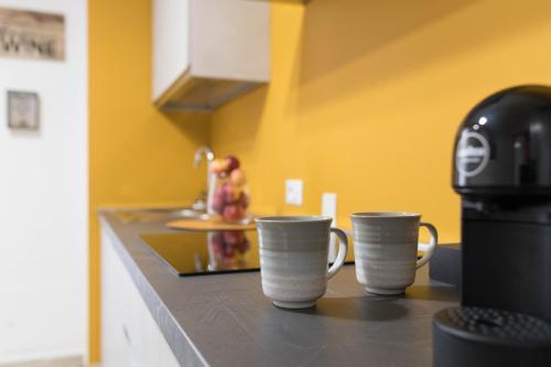 three coffee cups sitting on a counter in a kitchen at L'Attimo Guesthouse in Verona