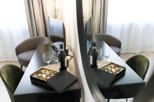 two tables with wine glasses and a mirror at L'Attimo Guesthouse in Verona