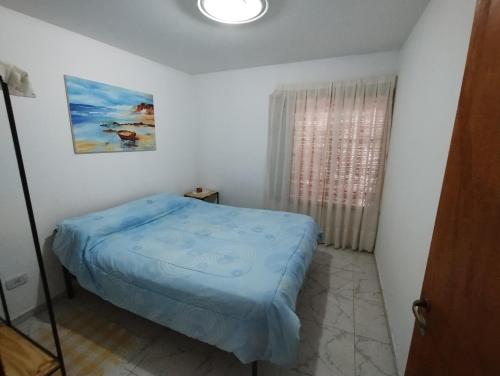 a small bedroom with a bed and a window at Tu Lugar in Tunuyán