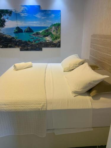 a bed with white sheets and pillows in a room at Marina Noronha Pousada in Fernando de Noronha