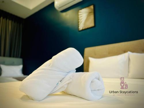 a pile of towels on a bed in a hotel room at New 2BR or 3BR Cozy Urban Suite Homestay at Georgetown8-10pax by URBAN STAYCATIONS LOD in Jelutong