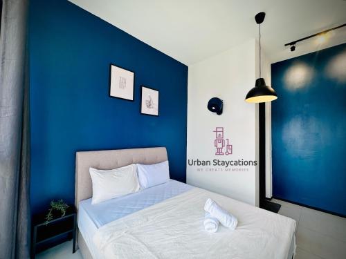 a bedroom with a blue wall and a bed at New 2BR or 3BR Cozy Urban Suite Homestay at Georgetown8-10pax by URBAN STAYCATIONS LOD in Jelutong