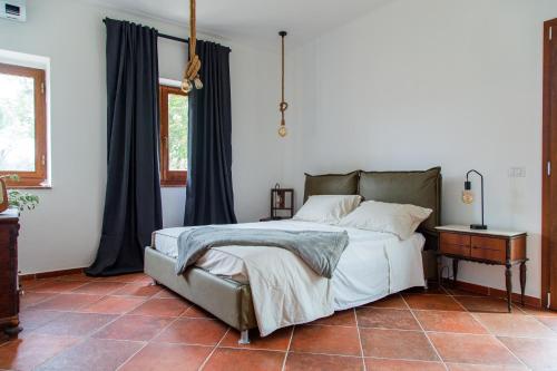 Schlafzimmer mit einem Bett, einem Tisch und einem Fenster in der Unterkunft Villa Orta - Agriturismo con cucina Vegan, Plant-based Farmhouse in Riotorto