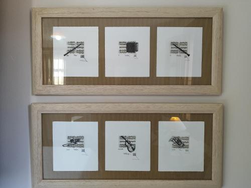 zwei Bilderrahmen mit Zeichnungen an einer Wand in der Unterkunft La Tienda de Porrúa in Llanes