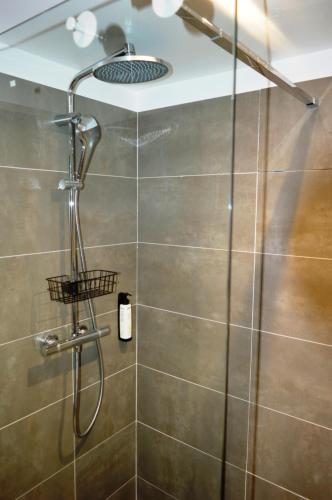 a shower with a shower head in a bathroom at Casa cu Magnolii in Poienile Izei