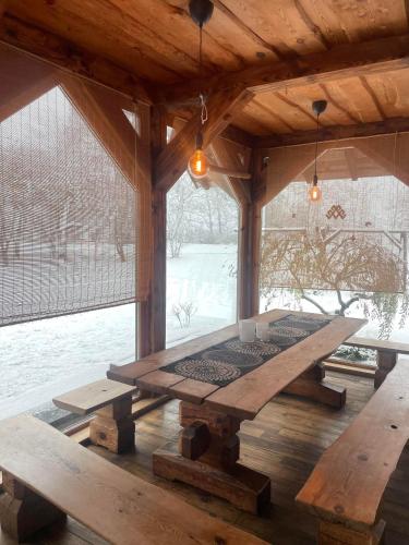 a wooden table in a pavilion with snow on the ground at Vecvanagi in Jaunmuiža