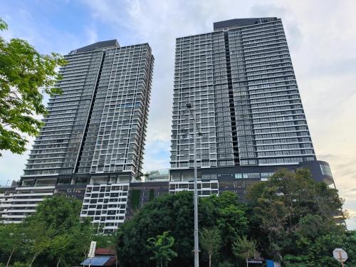 two tall buildings with trees in front of them at New 2BR or 3BR Cozy Urban Suite Homestay at Georgetown8-10pax by URBAN STAYCATIONS LOD in Jelutong