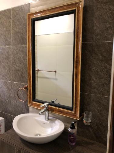 a bathroom with a sink and a mirror at Savwa Resort and Gardens in Kakamega