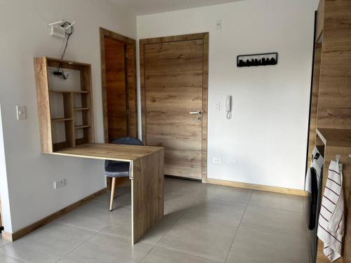 een kamer met een houten bureau en een deur bij Estudio luminoso con balcón in Quito