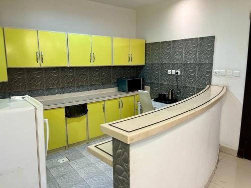 cocina con armarios amarillos y encimera en Al-Aniqa Furnished Apartments en Riad