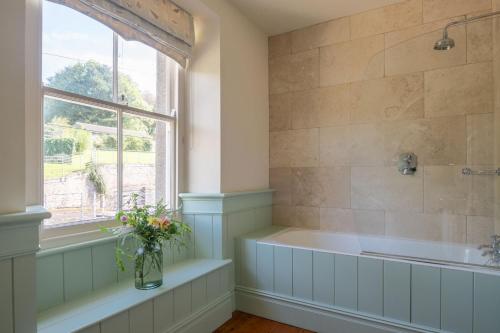 HolbetonにあるHarlequin Houseのバスタブと窓のあるバスルーム