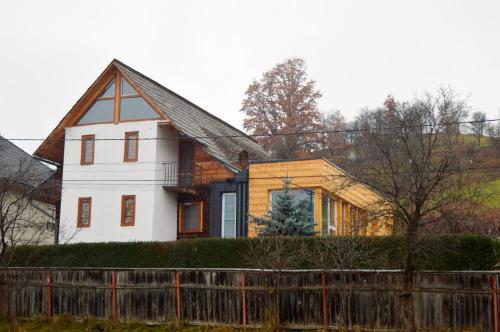 a white house with a wooden fence in front of it at Casa cu Magnolii in Poienile Izei