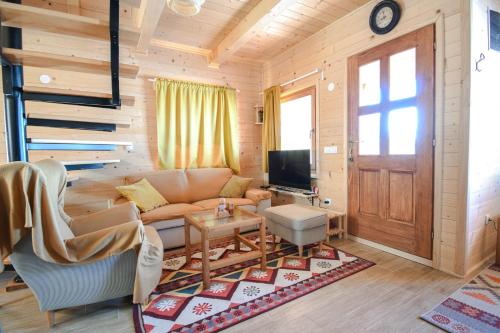 ein Wohnzimmer mit einem Sofa und einem TV in der Unterkunft Koliba Vuk in Sekulić 
