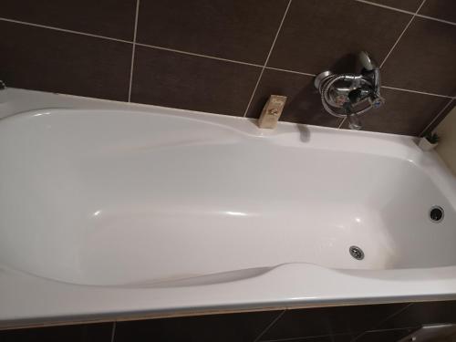 a white bath tub with a faucet in a bathroom at Natasa Apartman in Orosháza
