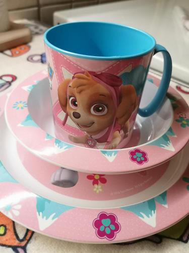 a disneyland cup and saucer with a doll on it at Natasa Apartman in Orosháza