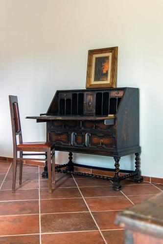 a wooden piano with a chair and a picture on the wall at Villa Orta - Agriturismo con cucina Vegan, Plant-based Farmhouse in Riotorto