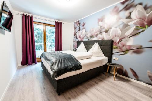 um quarto com uma cama com um mural de flores em Appartements Flor em Wasserhofen