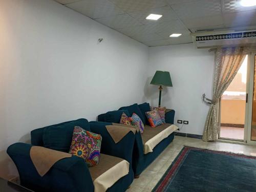 a living room with a blue couch with pillows at شقه مفروشه كورنيش المعادى in Cairo