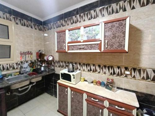 a kitchen with a sink and a microwave at شقه مفروشه كورنيش المعادى in Cairo