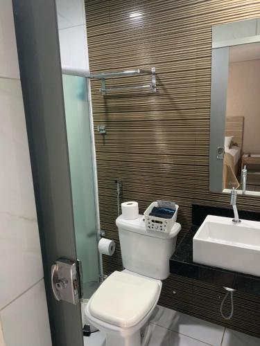 a bathroom with a white toilet and a sink at Marina Noronha Pousada in Fernando de Noronha