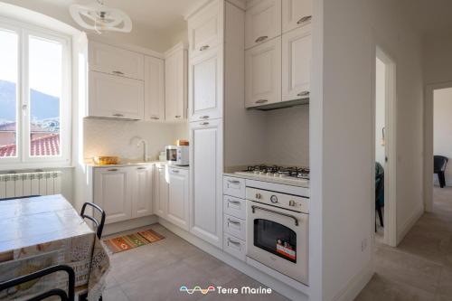 a kitchen with white cabinets and a stove top oven at BlueGreen in La Spezia