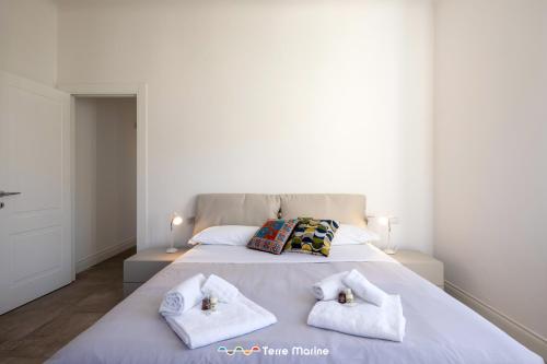 a bedroom with a large bed with white sheets and pillows at BlueGreen in La Spezia