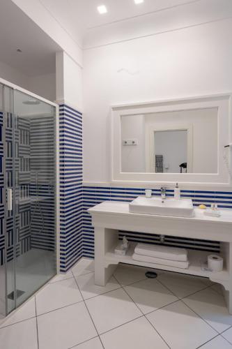 a white bathroom with a sink and a shower at Duomo Guest House - Stay in Sorrento in Sorrento
