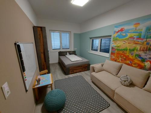 ein Wohnzimmer mit einem Sofa und einem Bett in der Unterkunft Villa Stefaner in Kirchbach