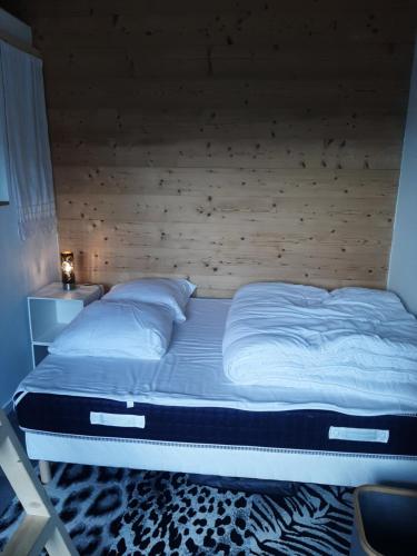 ein großes Bett mit einem Kopfteil aus Holz im Schlafzimmer in der Unterkunft 5 min des pistes de ski Grand studio mezzanine in Viuz-en-Sallaz