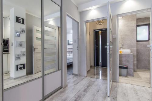 um corredor com espelhos e uma casa de banho com lavatório em Krupówki i Styl em Zakopane