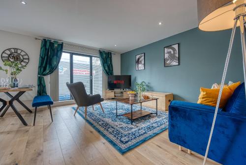 a living room with a blue couch and a table at 2-Bedroom Cosy, Spacious, & Modern City Apartment, Prime Location! Sleeps 6, Southampton Ocean Village - by Blue Puffin Stays in Southampton