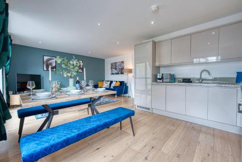 a kitchen and living room with blue and white cabinets at 2-Bedroom Cosy, Spacious, & Modern City Apartment, Prime Location! Sleeps 6, Southampton Ocean Village - by Blue Puffin Stays in Southampton