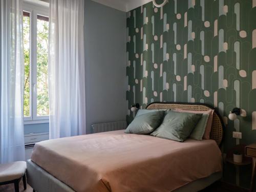 Un dormitorio con una cama con una pared verde estampada en Mini suite di design, en Milán