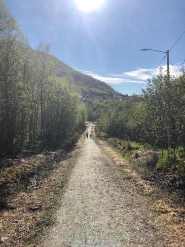 a dirt road with two people walking down it at Large house with spectacular view in Tromsø