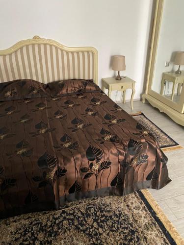 a bedroom with a bed with a brown comforter at Luxe à petit prix in Salambôo
