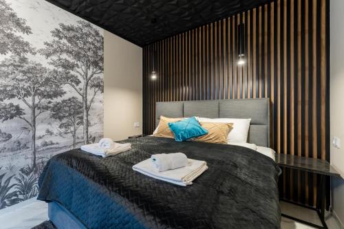 a bedroom with a large bed with towels on it at Apartament Widokowe Marzenie - blisko stoku, parking podziemny by SpaceApart in Karpacz