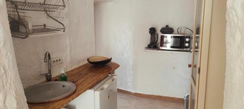 a small kitchen with a sink and a microwave at Cuevas Althea in Baza