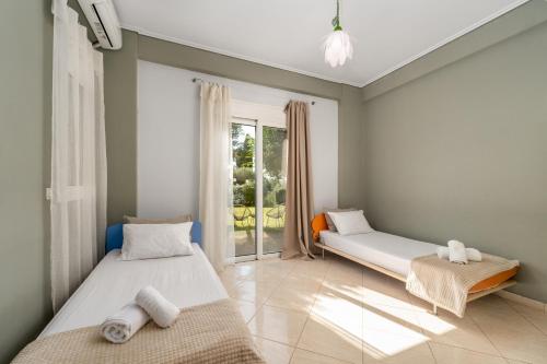 two beds in a room with a window at Piperitsa house for nomads or families in the countryside in Messini